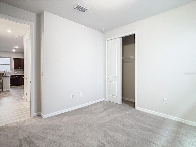 unfurnished bedroom featuring light colored carpet and sink