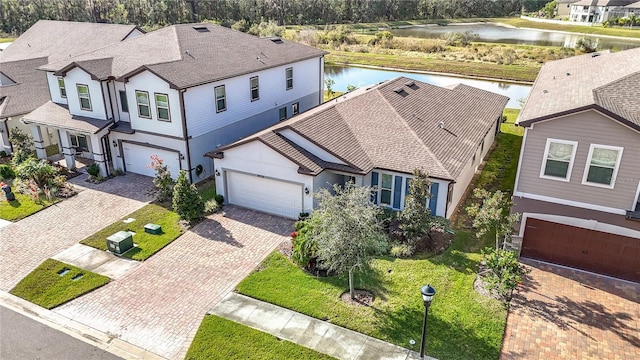 view of front of property featuring a water view, a front yard, and a garage