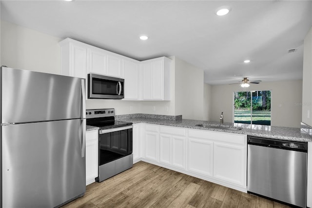 kitchen with light hardwood / wood-style floors, sink, white cabinetry, and stainless steel appliances