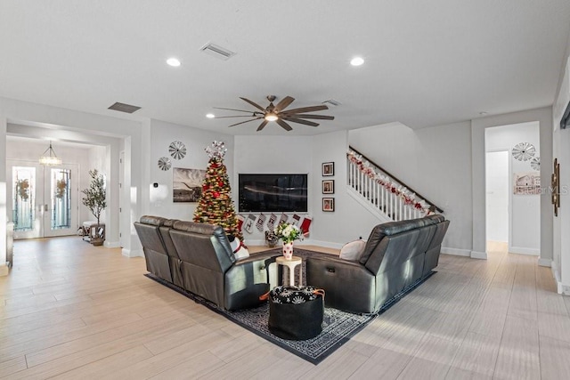 living room with ceiling fan and light hardwood / wood-style flooring