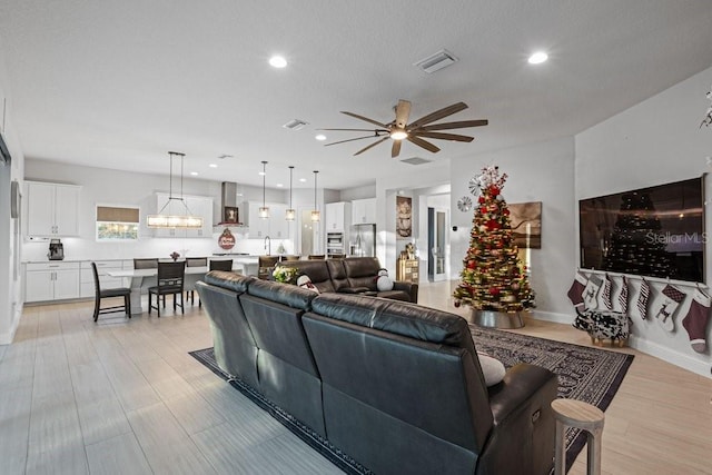 living room with ceiling fan and sink