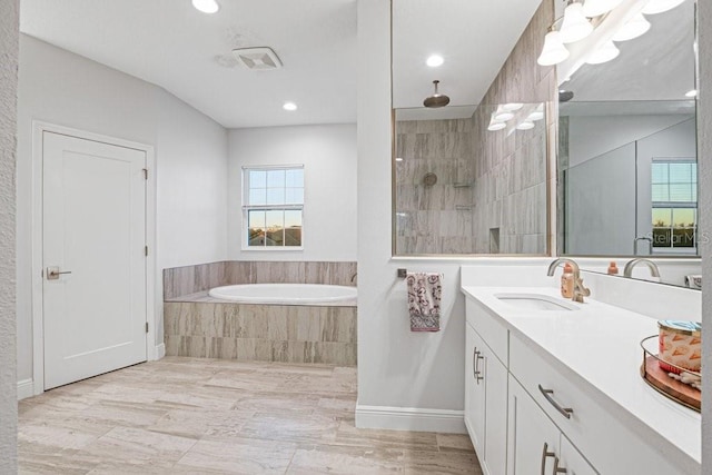 bathroom featuring independent shower and bath and vanity