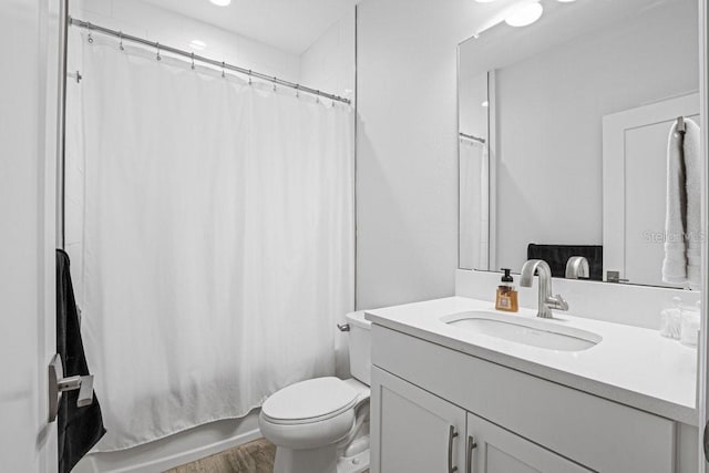 full bathroom featuring toilet, shower / bathtub combination with curtain, and vanity