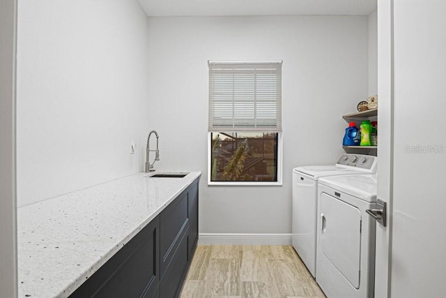 washroom featuring cabinets, sink, and washing machine and dryer