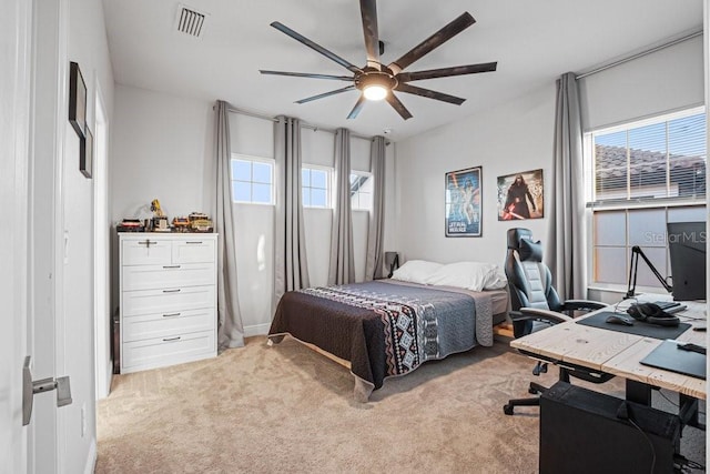 carpeted bedroom with ceiling fan and multiple windows