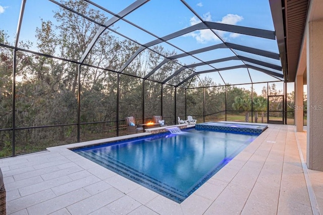 view of swimming pool featuring glass enclosure, a patio area, and a hot tub