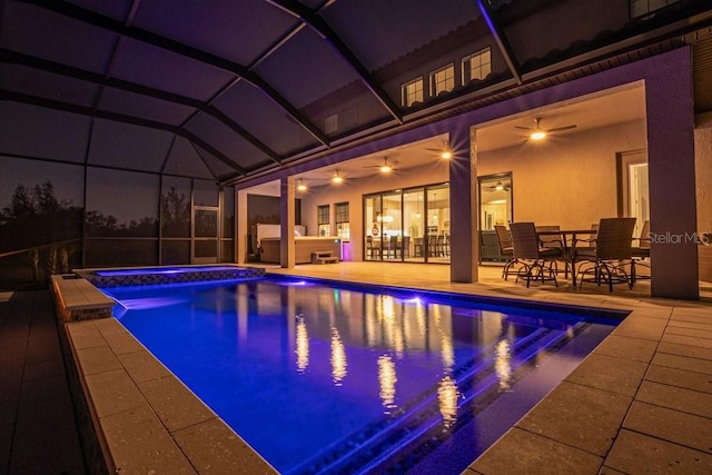 view of pool with glass enclosure, an in ground hot tub, ceiling fan, and a patio