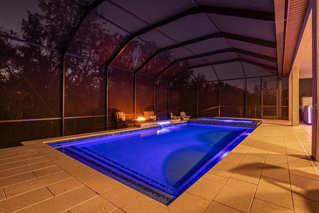 view of swimming pool featuring a patio area, glass enclosure, and an in ground hot tub