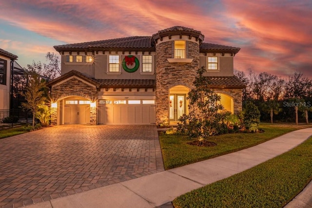 mediterranean / spanish home featuring a lawn and a garage