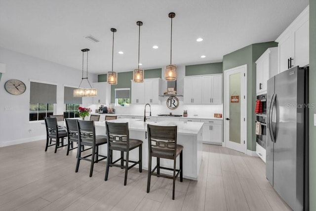 13019 Paddock Wood Pl, Riverview, FL 33579 - kitchen with appliances with stainless steel finishes, white cabinets, recessed lighting, a kitchen island with sink, and pendant lighting