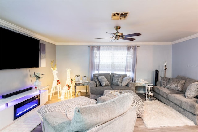 living room featuring ceiling fan, light hardwood / wood-style flooring, and ornamental molding