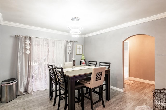 dining room with crown molding and wood-type flooring