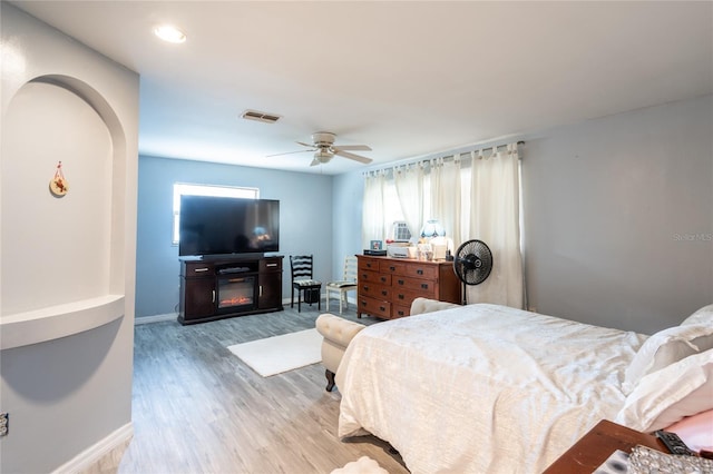 bedroom featuring light hardwood / wood-style flooring, multiple windows, and ceiling fan