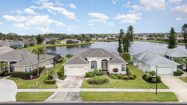 view of front of property with a garage, a water view, and a front yard