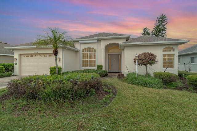 view of front facade featuring a garage and a yard