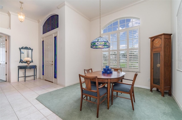 dining room featuring plenty of natural light, light tile patterned flooring, crown molding, and a high ceiling