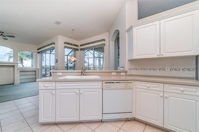 kitchen with white dishwasher, sink, kitchen peninsula, ceiling fan, and white cabinetry