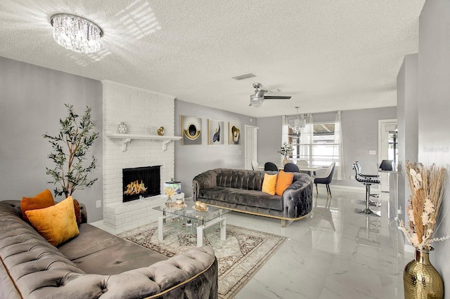 living room with a fireplace, ceiling fan with notable chandelier, and a textured ceiling