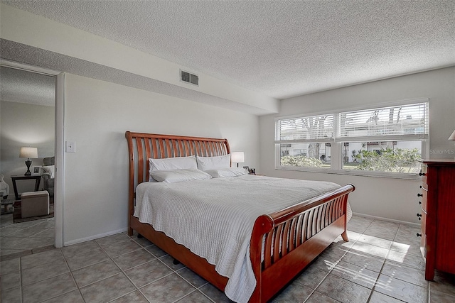 tiled bedroom with a textured ceiling