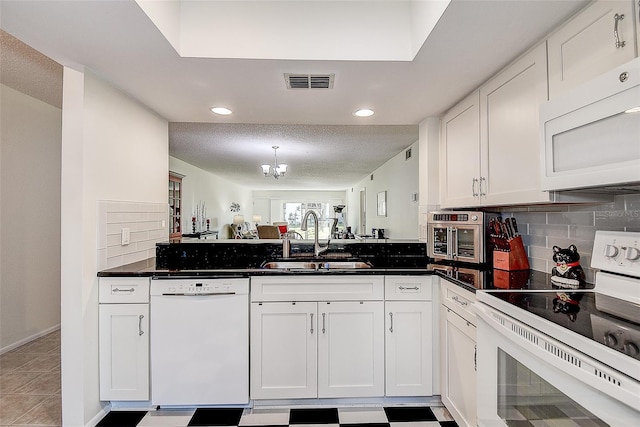 kitchen with a textured ceiling, white appliances, sink, a notable chandelier, and white cabinets