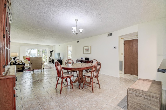 dining room featuring light tile patterned floors, a textured ceiling, and an inviting chandelier