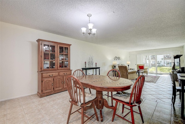 tiled dining area featuring a textured ceiling and an inviting chandelier