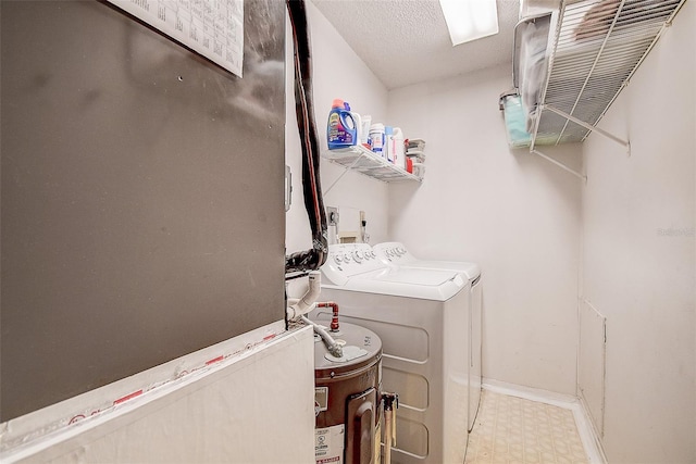 laundry area with water heater, a textured ceiling, and independent washer and dryer