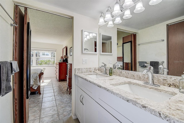 bathroom featuring a textured ceiling, vanity, tile patterned floors, and a notable chandelier