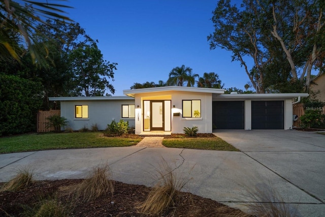 view of front of property featuring a garage and a lawn