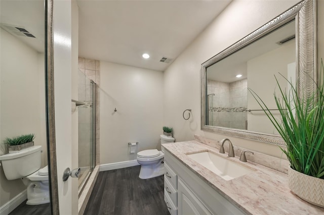 bathroom with hardwood / wood-style floors, vanity, toilet, and an enclosed shower