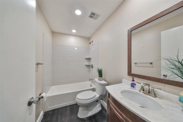 full bathroom featuring wood-type flooring, vanity, toilet, and tiled shower / bath