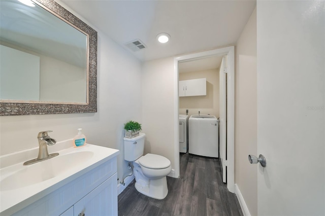 bathroom featuring toilet, washer and clothes dryer, vanity, and hardwood / wood-style flooring