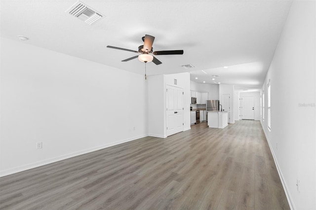 unfurnished living room featuring ceiling fan and light wood-type flooring