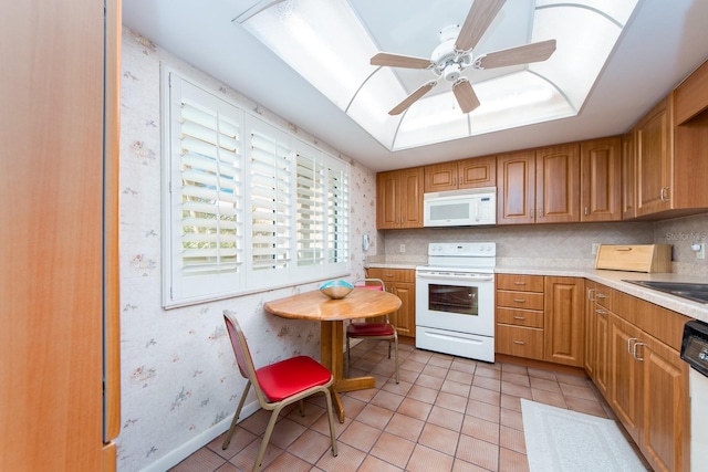 kitchen featuring ceiling fan, white appliances, sink, and light tile patterned floors