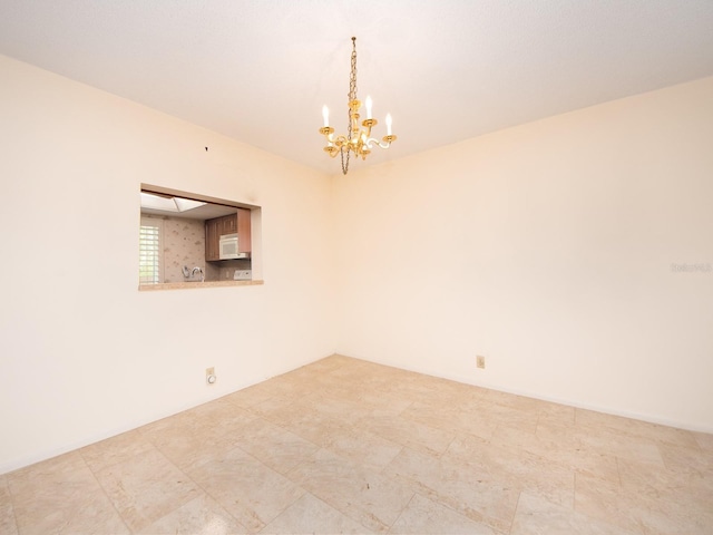 empty room featuring a chandelier