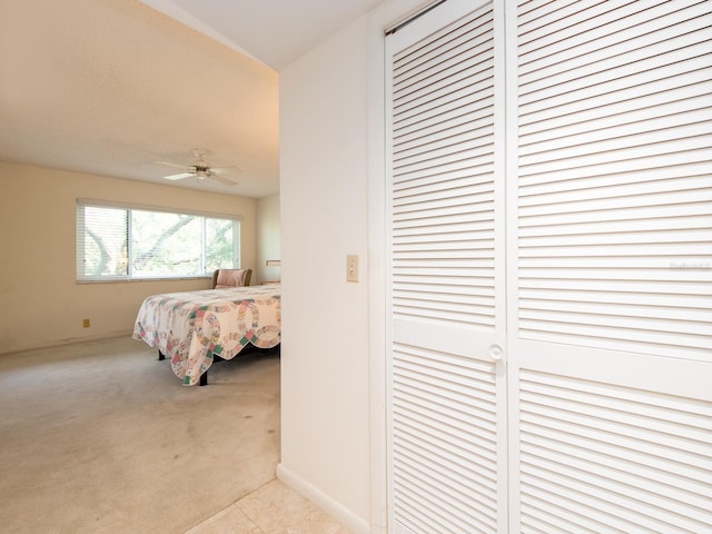 bedroom with ceiling fan, a closet, and light colored carpet