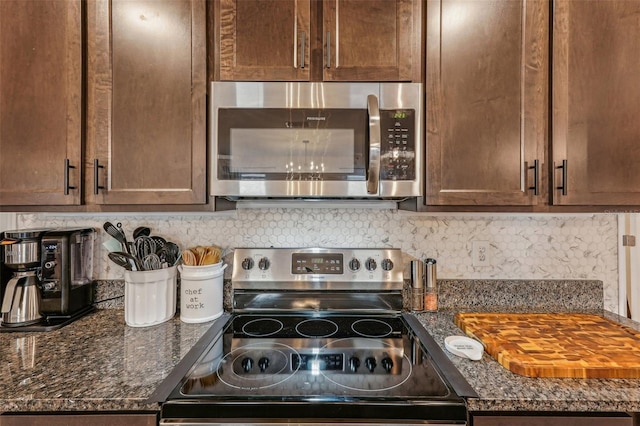 kitchen with stainless steel appliances, tasteful backsplash, and dark stone counters