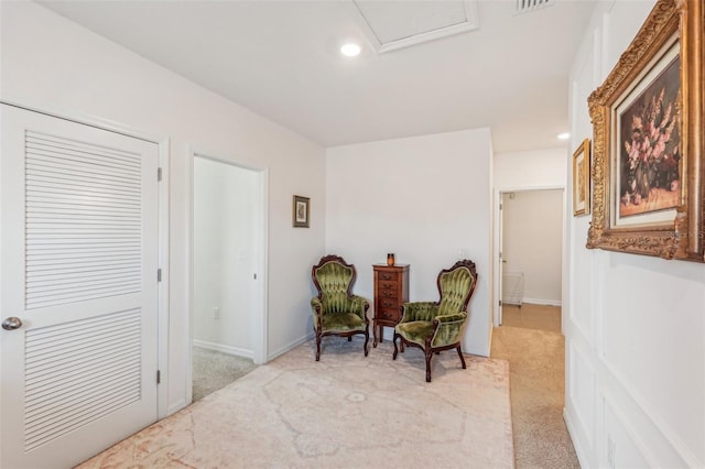 sitting room featuring light colored carpet