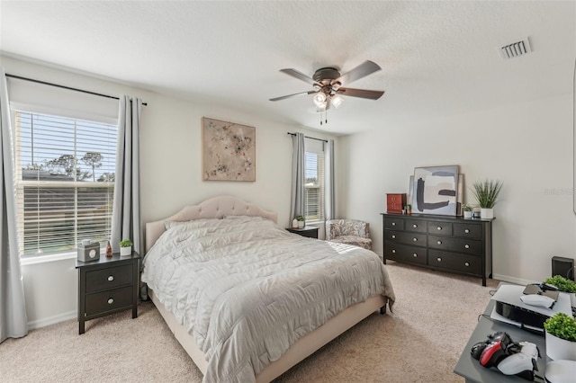 carpeted bedroom featuring a textured ceiling and ceiling fan