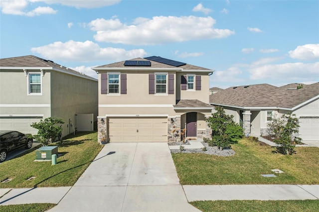 front of property with a front yard, solar panels, and a garage