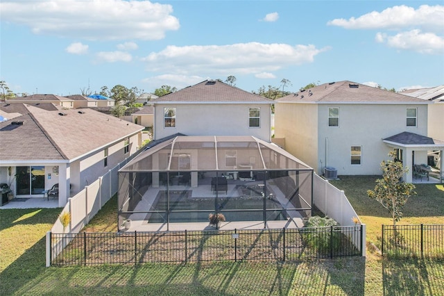 rear view of house featuring a pool, a patio, glass enclosure, and a lawn