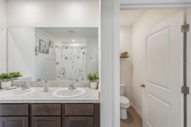 bathroom featuring vanity, curtained shower, and toilet