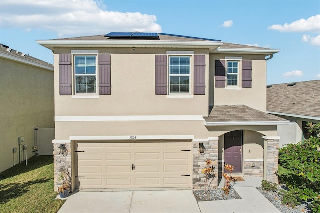 view of front facade featuring solar panels and a garage