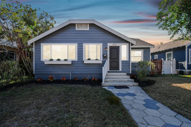 bungalow-style home with a yard