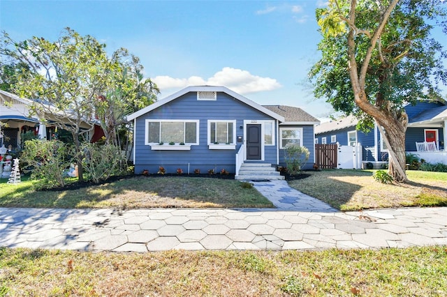 bungalow-style house featuring a front lawn