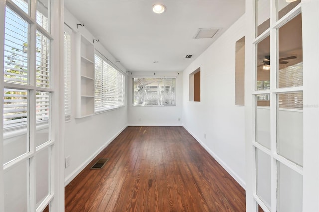 unfurnished sunroom featuring ceiling fan