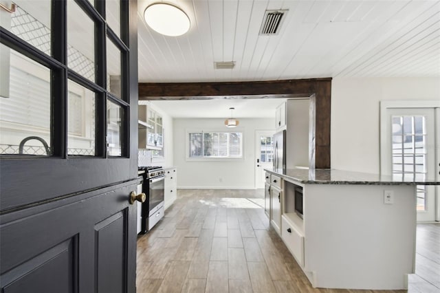 interior space featuring beamed ceiling, light hardwood / wood-style floors, and a wealth of natural light