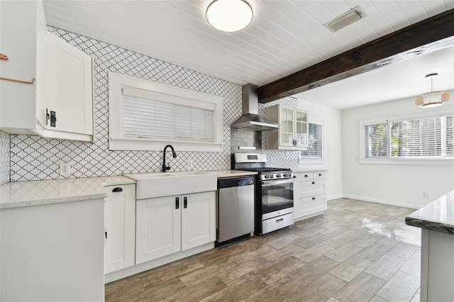 kitchen with white cabinets, stainless steel appliances, and wall chimney range hood