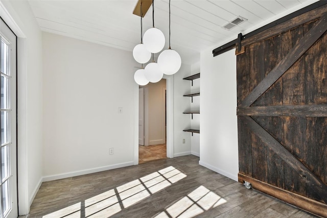 unfurnished room with a barn door, dark wood-type flooring, and wood ceiling