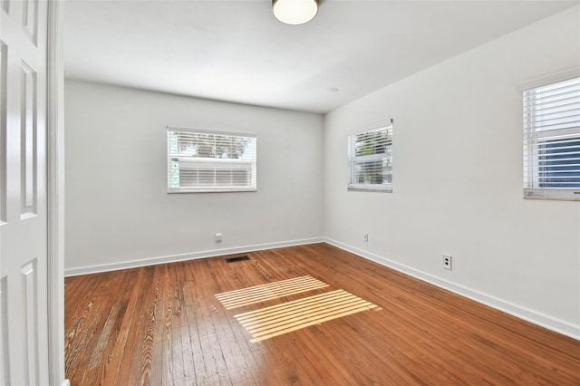 empty room featuring plenty of natural light and wood-type flooring